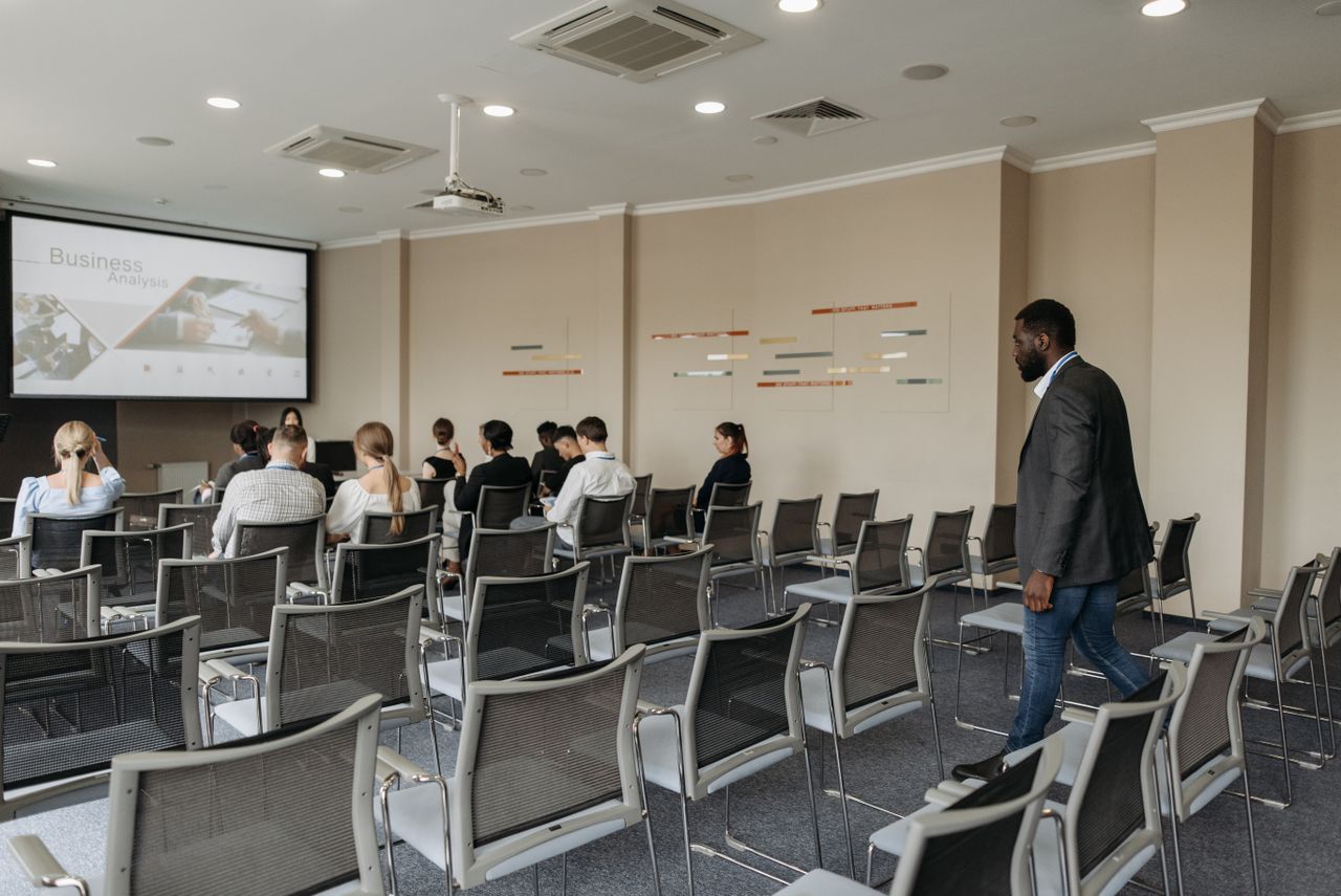 Attendees participate in a business analysis presentation in a contemporary conference room.